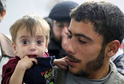 Una foto del Programa Mundial de Alimentos muestra en Gouta a un padre sosteniendo a su hijo, que padece malnutrición