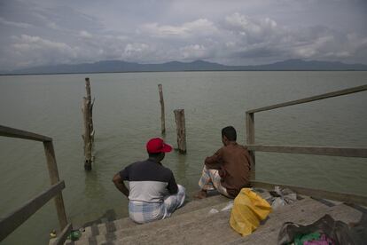 Dos pescadores bangladesíes descansan en un embarcadero en el campo de repatriación de Rohingyas de Kerontali, destinado a enviar refugiados a Myanmar a través del río Naf.