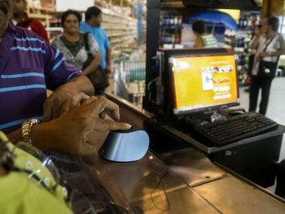 Clientes se identificam no sistema de compras biométrico em Maracaibo.