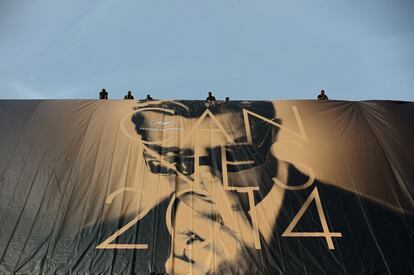 Unos operarios cuelgan el cartel promocional de la 67º edición del festival de cine de Cannes, en 2014, con la foto de Marcello Mastroianni en 'Fellini 8 ½'.