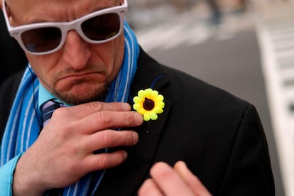 Un manifestante se coloca un alfiler con forma de girasol durante una protesta contra la invasión rusa de Ucrania en Lafayette Square, en Washington (EE UU), el 1 de marzo.