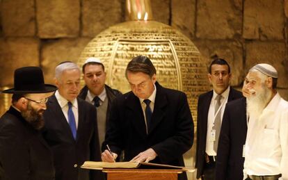 Bolsonaro firma un libro junto Netanyahu y el rabino del Muro de las Lamentaciones,este lunes. 