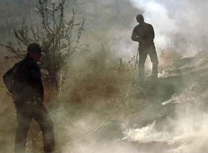 Miembros de los servicios de urgencias luchan contra uno de los incendios declarados en agosto en el Peloponeso.