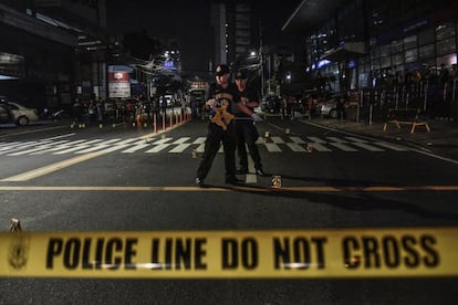 Miembros de la Policía Nacional de Filipinas (PNP) acordonan la escena de un crimen en la ciudad de Mandaluyong, al este de Manila (Filipinas).