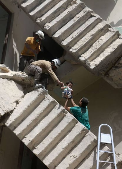 Amplias zonas de Alepo han sido destruidas y sus infraestructuras están gravemente afectadas, por lo que los civiles no tienen agua ni electricidad durante meses. En la imagen, unos voluntarios rescatan a un bebé entre los escombros de un edificio en Alepo (Siria), el 28 de abril de 2016.