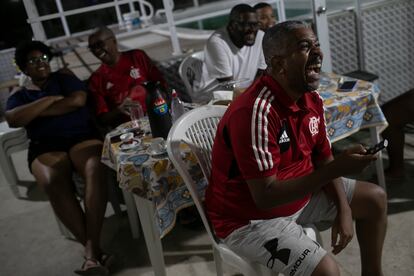 Rafael de Oliveira Encarnacao, de 42 años, observa el debate en compañia de familiares y amigos en Duque de Caxias, en Río de Janeiro.