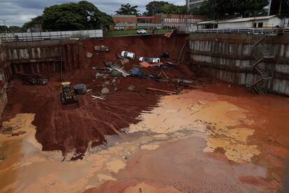 Varios coches yacen en un terreno en construcción después de que un camino se derrumbara debido a las fuertes lluvias en el centro de Brasilia (Brasil).