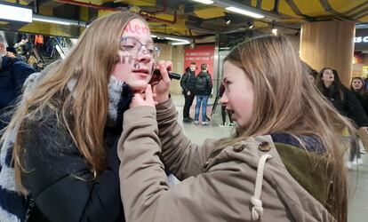 Una alumna pinta la cara de una compañera rumbo a una de las protestas en Bruselas.
