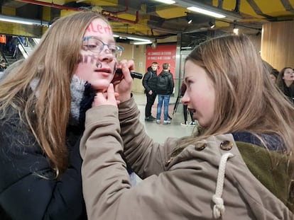 Una alumna pinta la cara de una compañera rumbo a una de las protestas en Bruselas.
