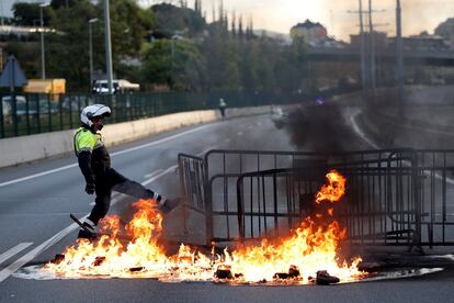 Un agente junto a una de las barricadas que cortan la Ronda de Dalt, en Barcelona.