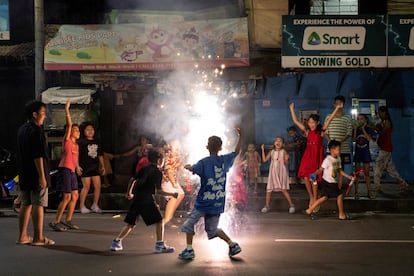 Un grupo de niños juegan con pirotecnia durante las celebraciones por el Año Nuevo, en Manila (Filipinas).