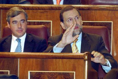 Rajoy levanta la mano para intervenir tras el discurso de Zapatero en el Congreso.