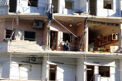Una persona sentada en los restos de lo que fue el balcón de un edificio de viviendas dañado, en el barrio de Al-Sukkari, en Alepo.