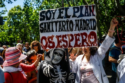 Un manifestante disfrazado de esqueleto muestra un cartel contra la política sanitaria de la Comunidad de Madrid.