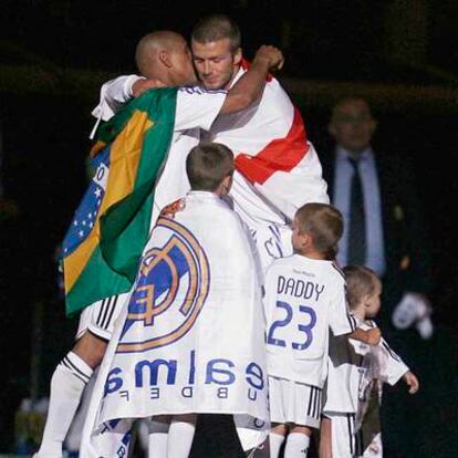 Beckham se abraza a Roberto Carlos junto a los hijos del jugador inglés.