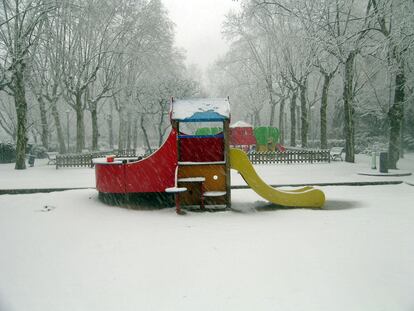La zona infantil del parque de Santa Amelia, en el barcelonés barrio de Sarrià, cubierta por la nieve.