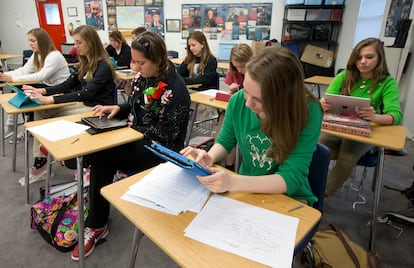 A group of female students at a high school in Austin, Texas, operate their tablets in class.