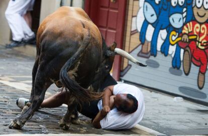 Toro de la ganadería de Cebada Gago embiste a un mozo durante el segundo encierro de los Sanfermines de 2016.