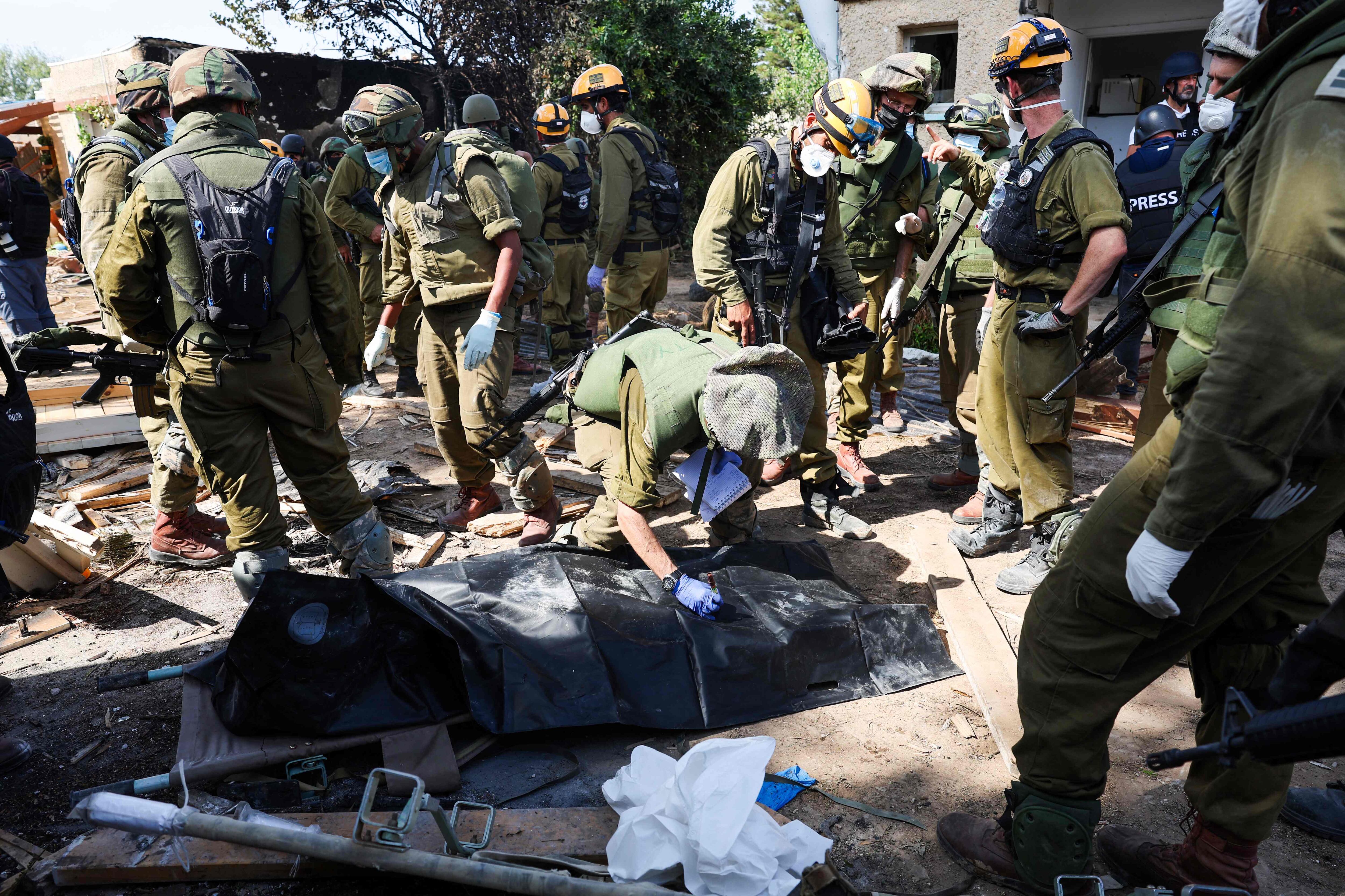 Soldados israelíes se preparan para retirar el cuerpo de un compatriota muerto durante el ataque de milicianos palestinos en el kibutz de Kfar Aza, al sur de Israel.