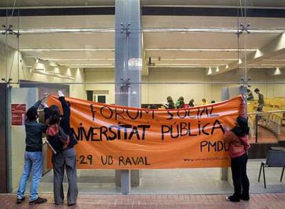 Tres estudiantes colocan una pancarta en la Pompeu Fabra en defensa de la universidad pública.