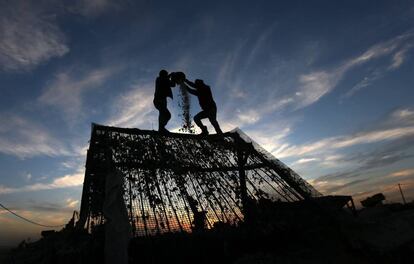 Un par de palestinos trabaja en una fábrica que recicla los escombros de casas palestinas destruidas durante la guerra israelí contra Gaza transformados en materiales de construcción, en el este de la ciudad de Gaza.