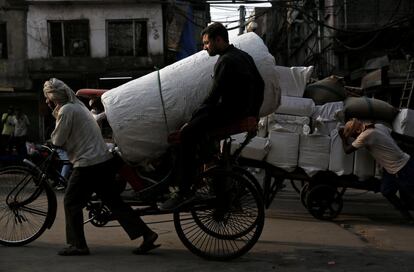 Dos hombres transportan mercancia en Old Delhi (India).