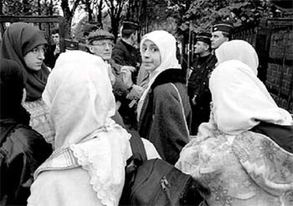 Mujeres musulmanas cubiertas con el velo intentan entrar en un colegio de Lille bloqueado por la policía.