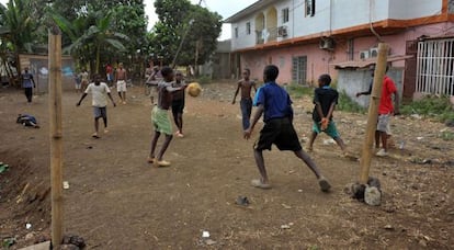 Young boys in Equatorial Guinea play football on a dry field in Malabo.
