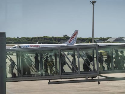 Un grupo de pasajeros accede a un avi&oacute;n desde la terminal 1 del aeropuerto de Barcelona-El Prat.