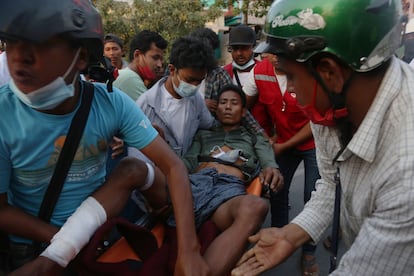 Translado de um homem depois que a polícia reprimiu aos manifestantes em um protesto em Mandalay (Myanmar), este domingo.
