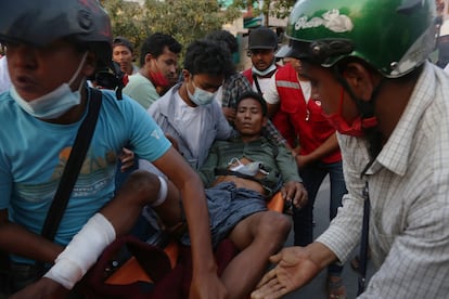 Translado de um homem depois que a polícia reprimiu aos manifestantes em um protesto em Mandalay (Myanmar), este domingo. 
