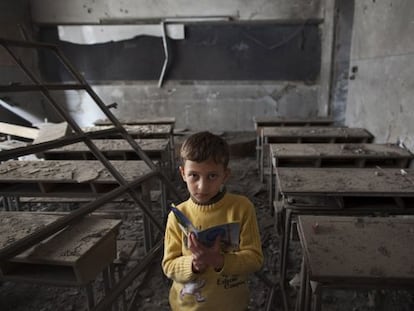 Ali, de 9 años, posa en su escuela, destruida por un bombardeo, en Alepo.