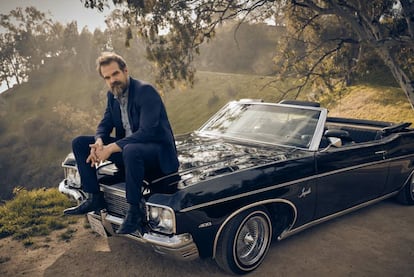 David Harbour viste traje Dolce & Gabbana. A diferencia del coche, las botas son suyas.