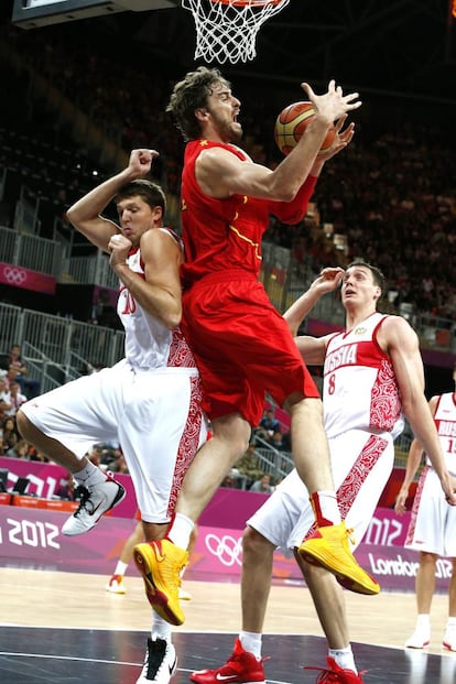 Pau Gasol recupera un balón bajo la canasta ante los rusos Sasha Kaun y Víctor Khryapa.