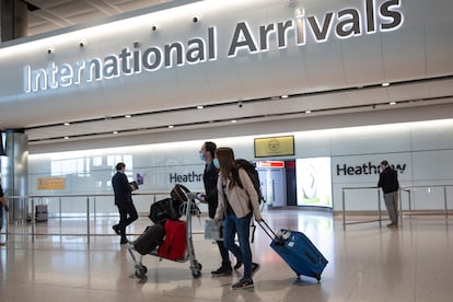 Passengers wearing face masks arrive at London's Heathrow Airport on June 8.