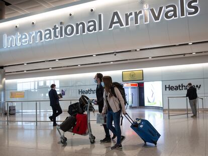 Passengers wearing face masks arrive at London's Heathrow Airport on June 8.