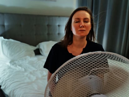 Una mujer intenta refrescarse frente a un ventilador.