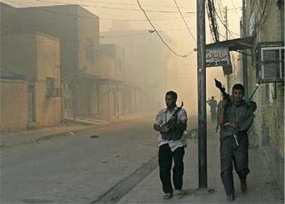 Dos chiíes patrullan armados las calles de Nayaf, donde las tropas de EE UU aseguran haber matado a 300 radicales.