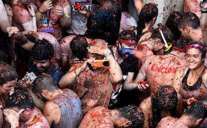 A man takes a photo with his cellphone during the 2018 Tomatina.