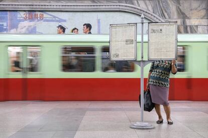 Una viajera lee un periódico en un panel de una estación de metro del metro de Pyongyang. Corea del Norte se prepara para celebrar el 70 aniversario de su fundación el 9 de septiembre.