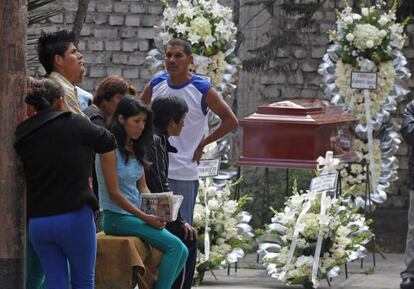 Familiares de una de las víctimas del incendio de un centro de rehabilitación de Lima velan el féretro con sus restos.