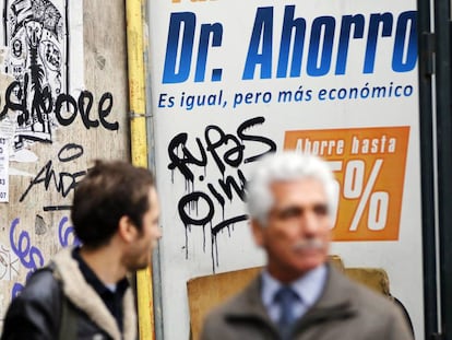 Dos personas caminan frente a un anuncio en Santiago de Chile el pasado martes.