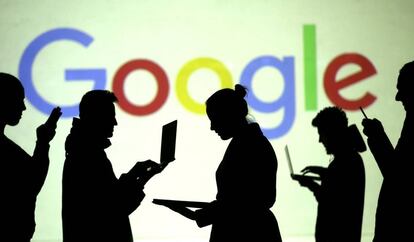 Varias personas con dispositivos móviles ante un logo de Google.