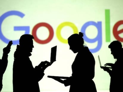 Varias personas con dispositivos móviles ante un logo de Google.