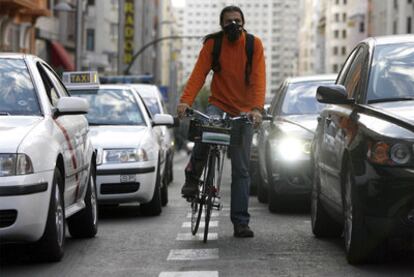 Un ciclista sortea el tráfico en la Gran Vía de Madrid.