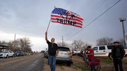 Un hombre ondea una bandera mientras espera la llegada del convoy "Recuperemos nuestra frontera" en Quemado, Texas, el 2 de febrero de 2024.