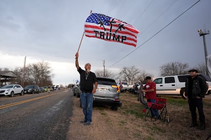 A man waves a flag as he waits for the arrival of the Take Our Border Back convoy in Quemado, Texas, last Friday.