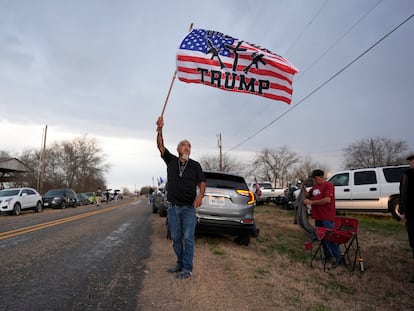 Un hombre ondea una bandera mientras espera la llegada del convoy “Recuperemos nuestra frontera” en Quemado, Texas, este viernes.