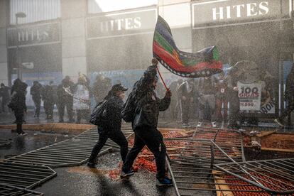 Un hombre sostiene una bandera mapuche durante una manifestación frente al antiguo congreso nacional durante el primer día de la convención constitucional. En julio de 2021.