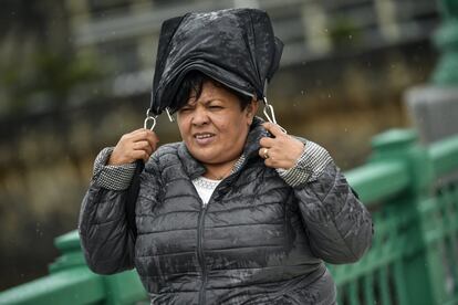 Una mujer se cubre de la lluvia en San Sebastián, el 14 de octubre de 2018. 